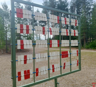Tulostaulu metsästystrap-radalla. Kullakin ampujalla on oma rivi. Valkoinen on osuma, punainen on ohilaukaus.